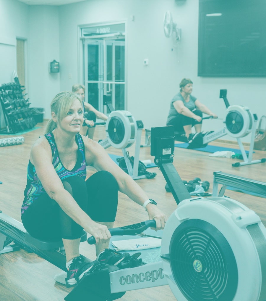 Woman rowing during a fitness class at Kingwood Fitness